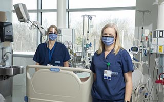 Irene Watpool (left) and Rebecca Porteous (right) stand by an empty ICU bed